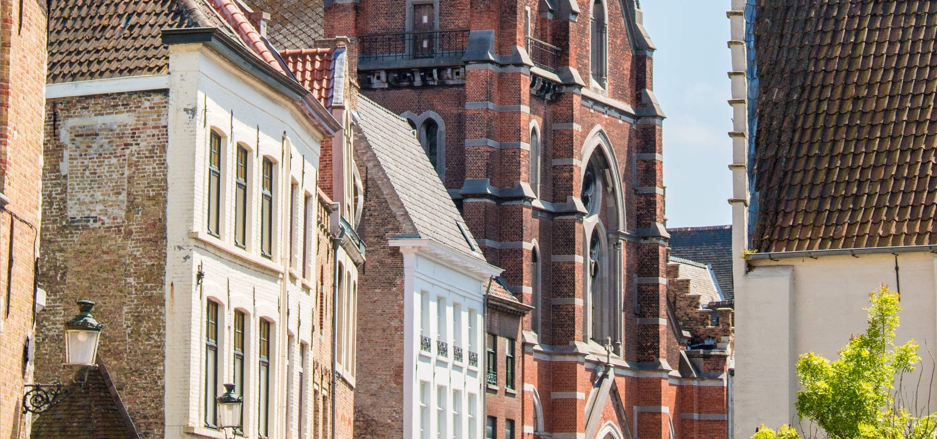 Drukke winkelstraat Vlamingstraat in Brugge met zijn kerk.