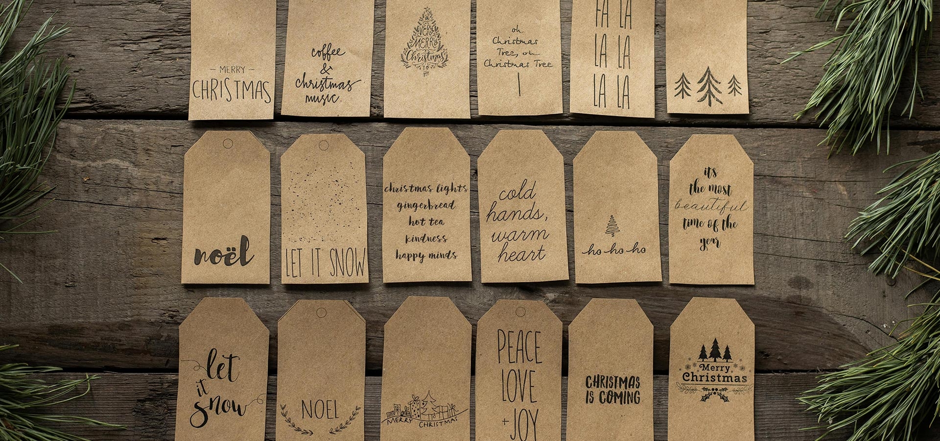 Handgemaakte kerstlabels met teksten en kersttakken op een houten tafel