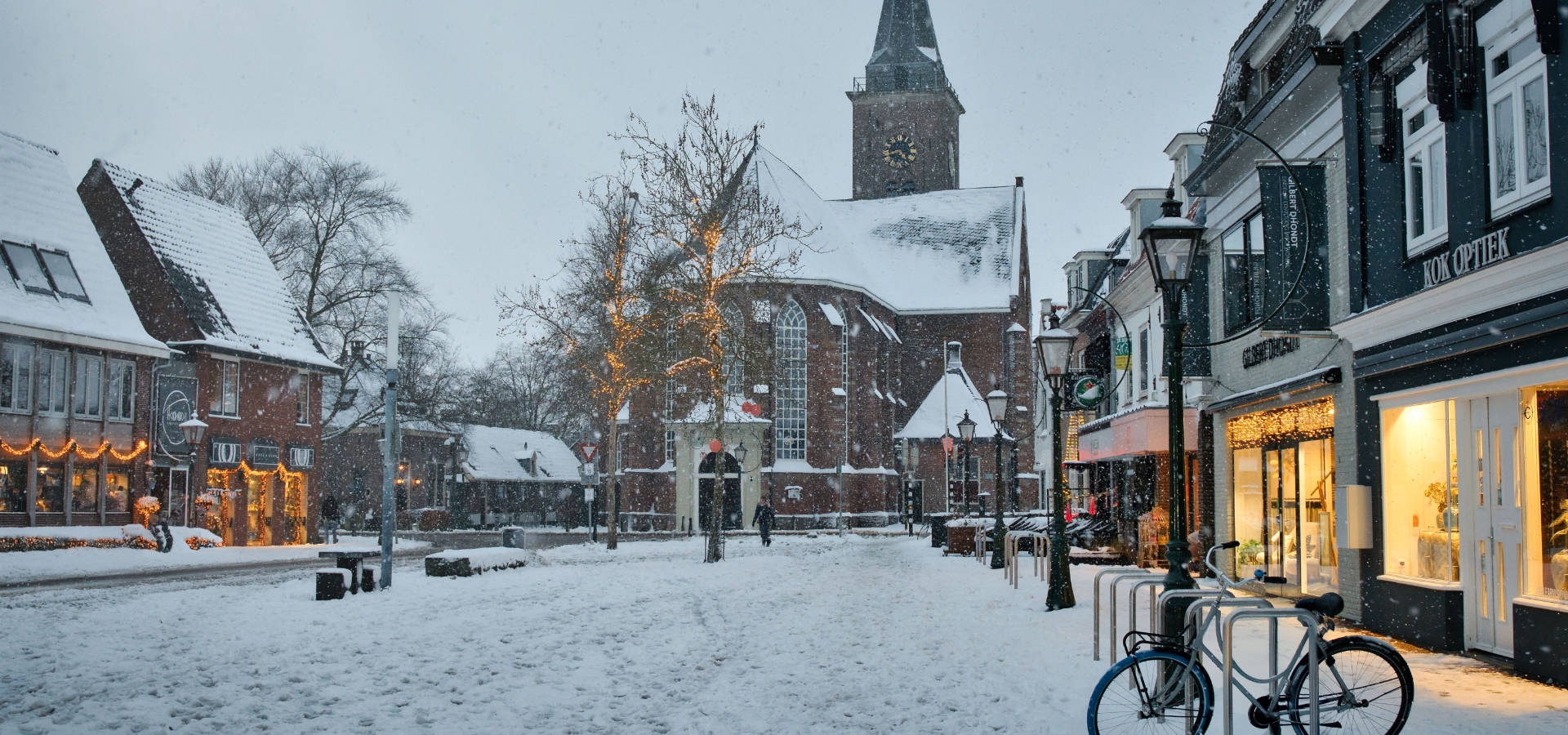 Brede fietsbanden op een nat winters fietspad richting de kerstmarkt