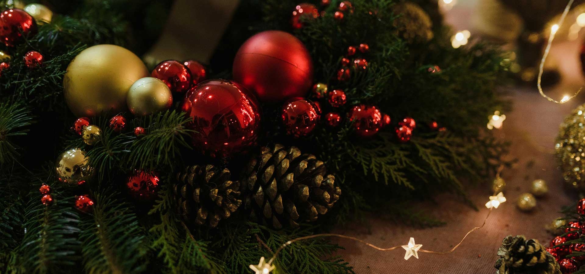 Kerstboom met klassieke rode, goudkleurige en zilveren kerstballen in warme sfeer