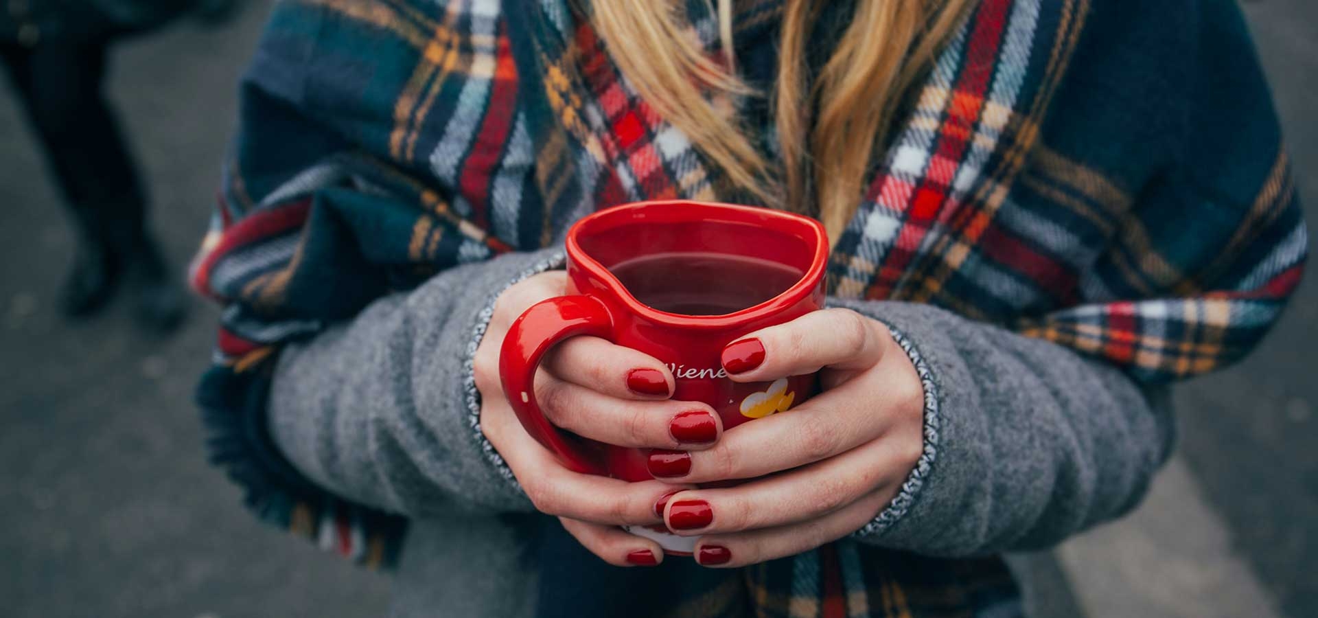 Bezoekers op een Duitse kerstmarkt met warme kleding en glühwein