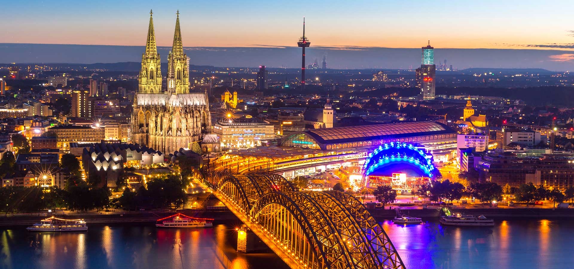 Kerstmarkt bij de Dom van Keulen met verlichte kraampjes en kerstboom