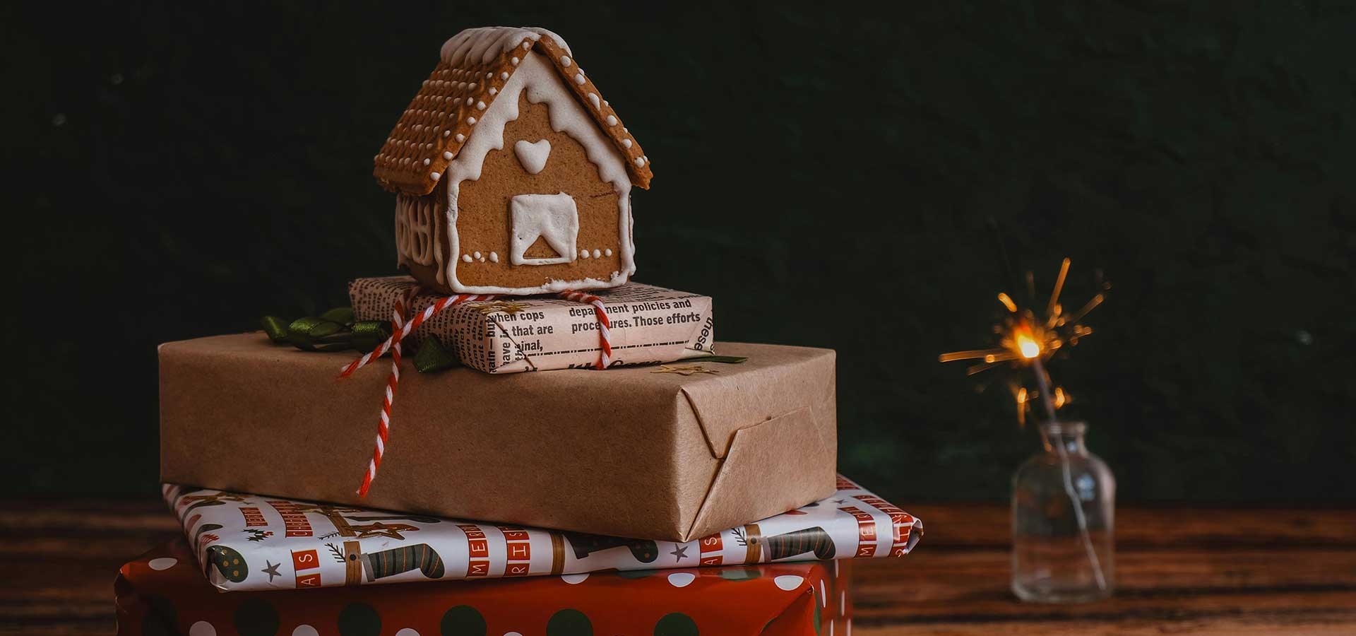 Peperkoekenhuisje op ingepakte kerstcadeaus.