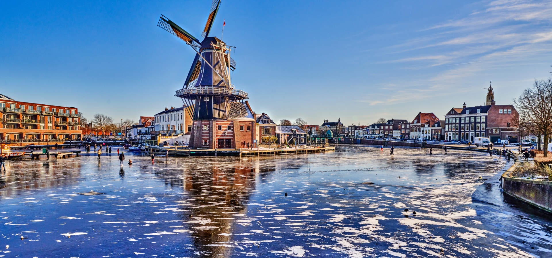 Schaatsen op het water van Haarlem bij de molen in de winter.