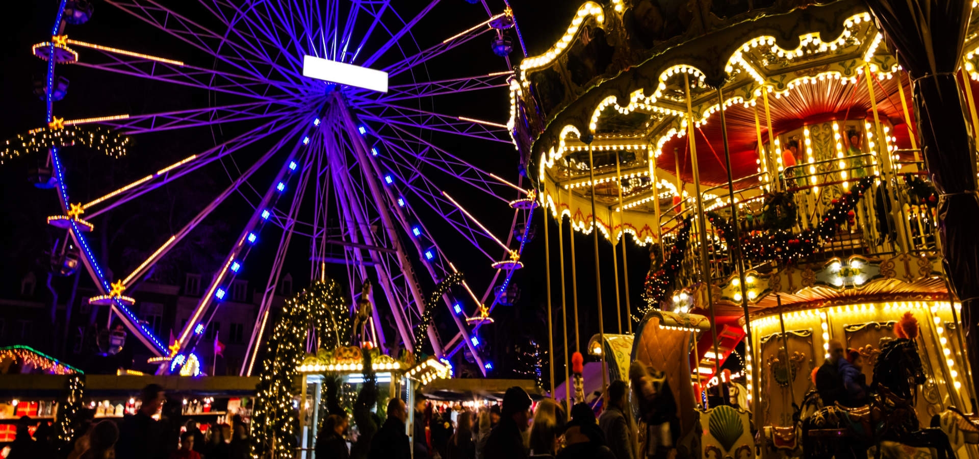 Sfeervol verlichte kerstmarkt met reuzenrad in Maastricht