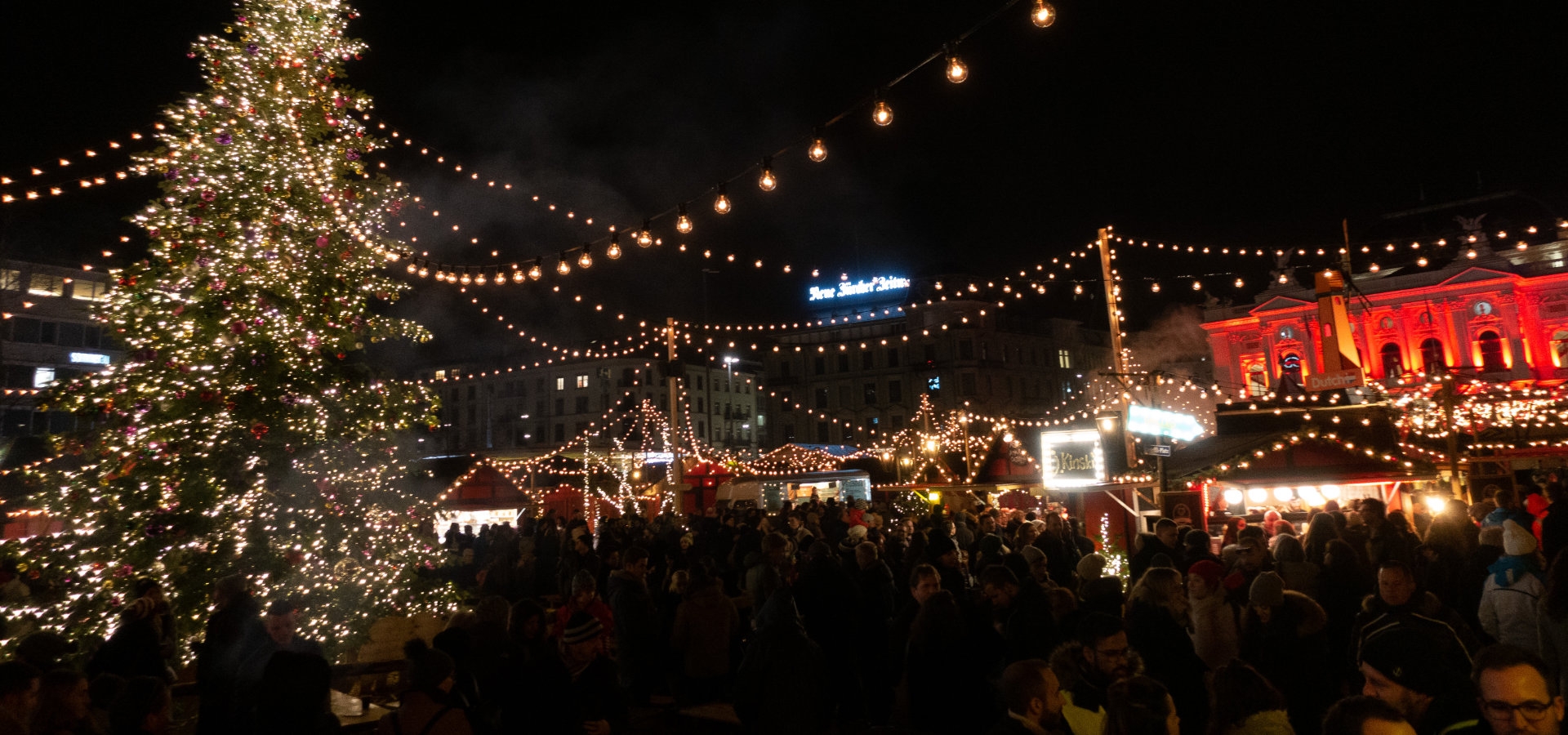 Sfeervolle kerstmarkt in Zurich met verlichte kraampjes en kerstboom