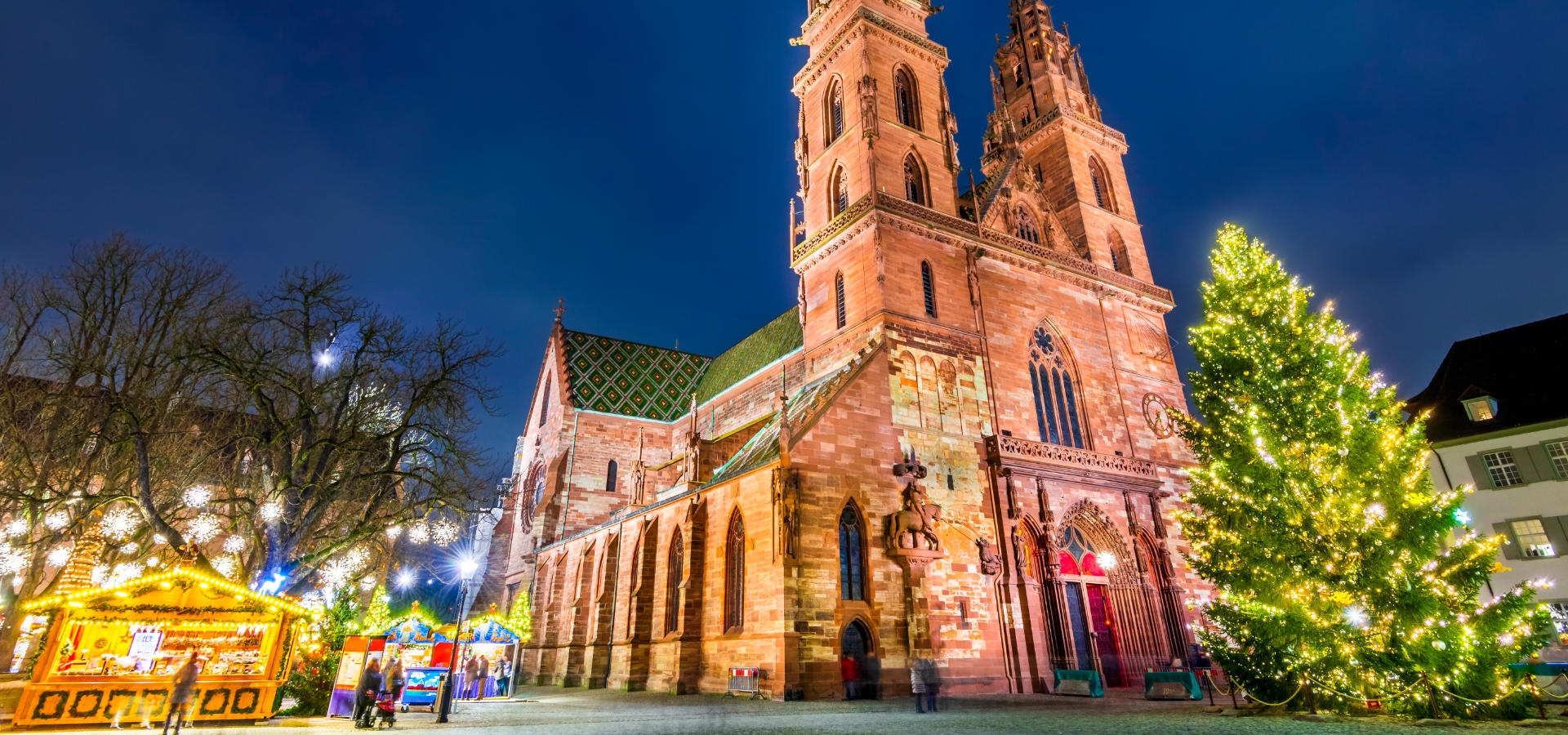 Verlichte kerstmarkt in Basel met houten chalets en winterse sfeer