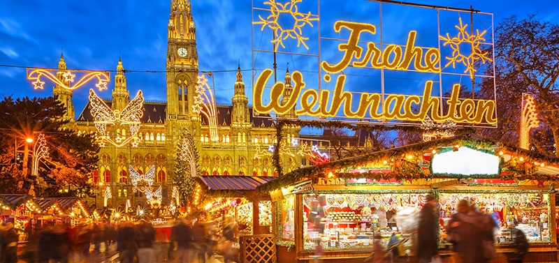 Kerstmarkt in Duitsland met welkomstbord verlicht met tekst Frohe Weihnachten